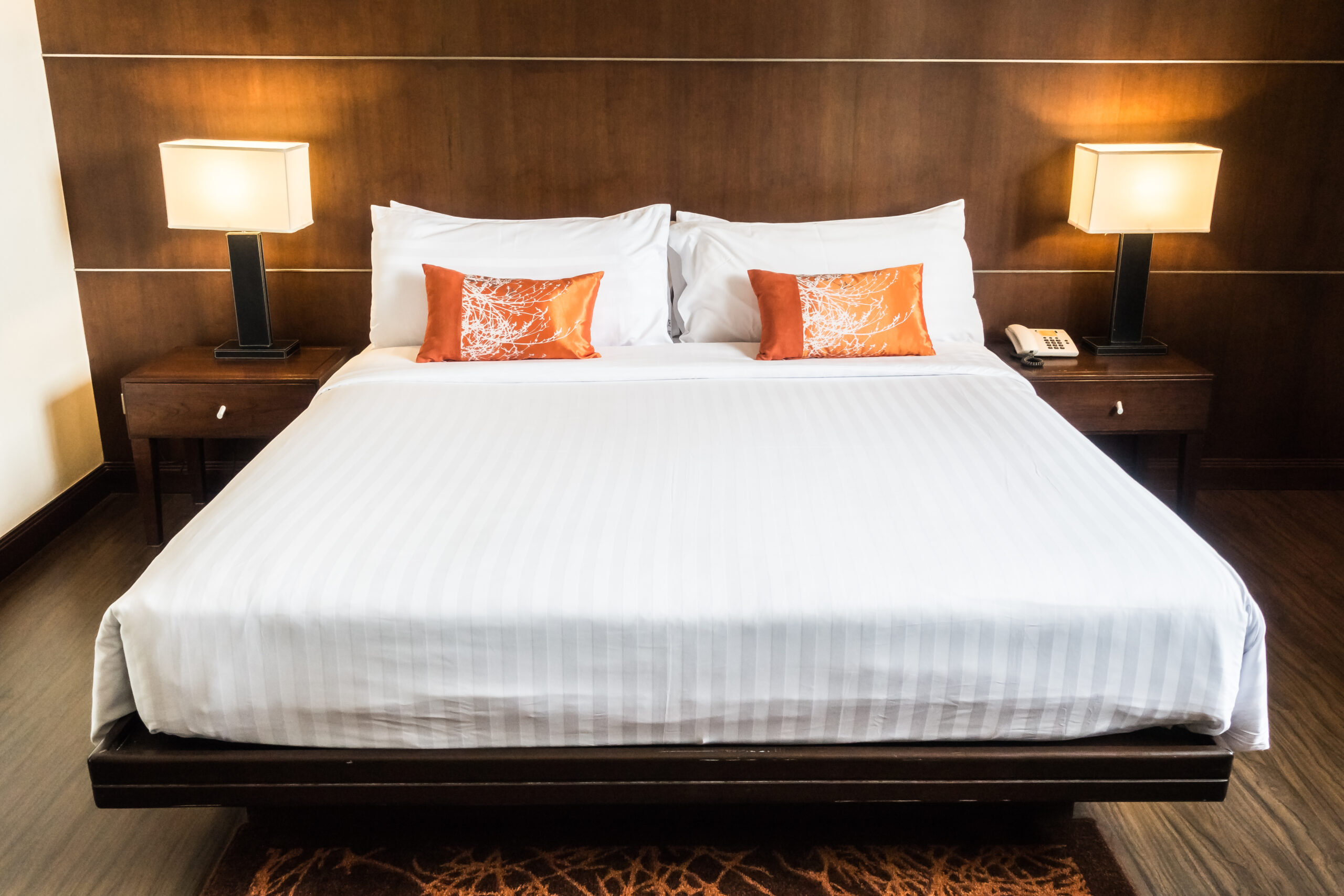 White pillow on bed decoration in bedroom interior with table light lamp